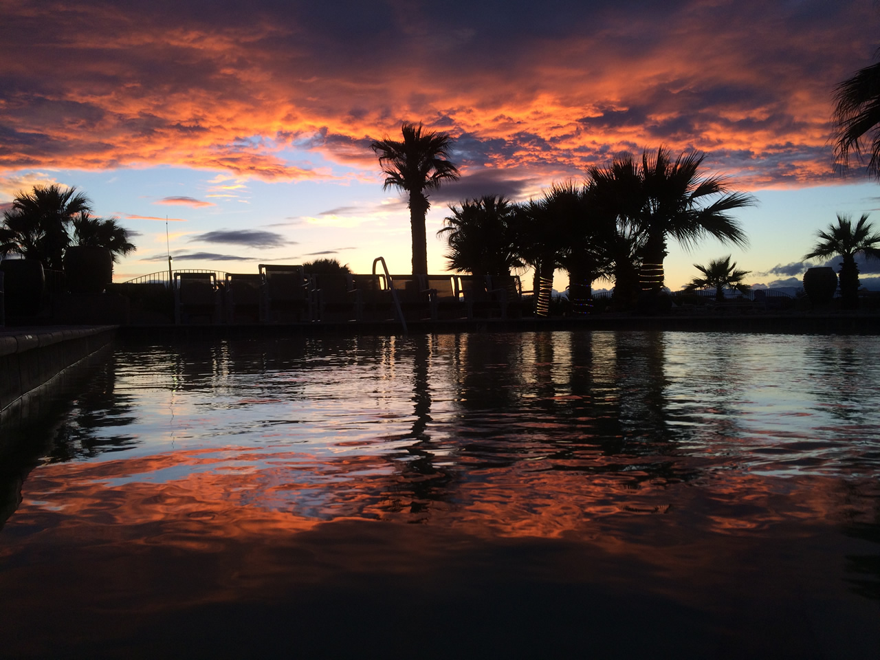 A picture of the sun setting over the Glamis North Hot Springs Resort pool complex